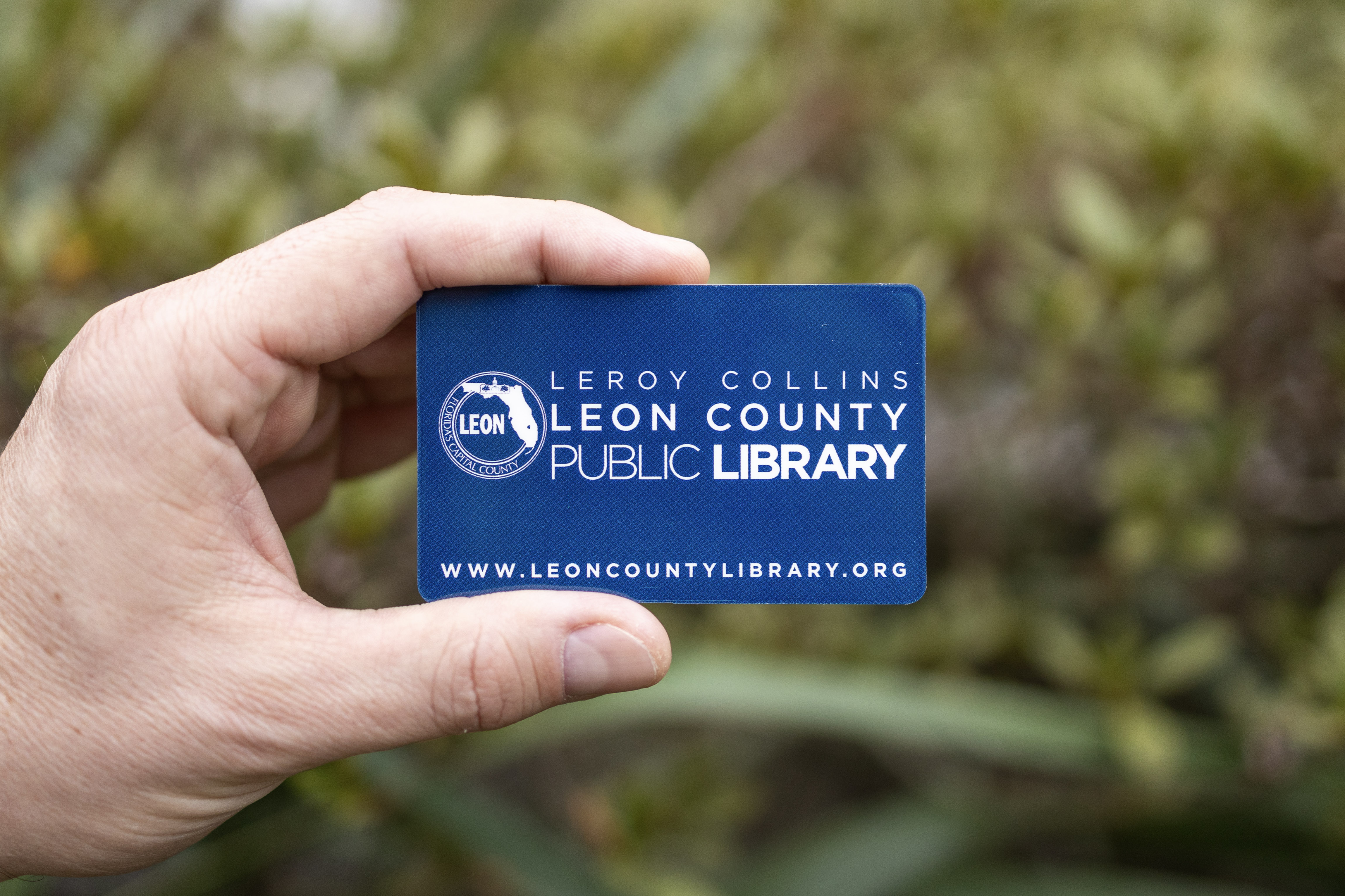 Blue Leon County Public Library card with white Leon County Public Library logo.